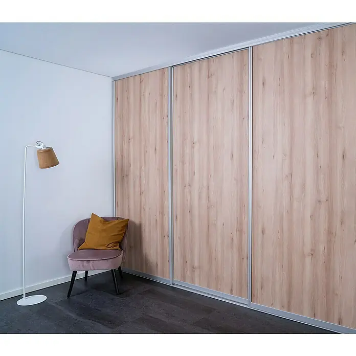 Room Plaza Easy Doing Schiebetür-Bau-Set - Buche Naturwuchs, Farbe Beschlag: Silber - Elegantes Zimmer mit einem Kleiderschrank mit Holzstruktur, einem Sessel und einer Stehlampe.