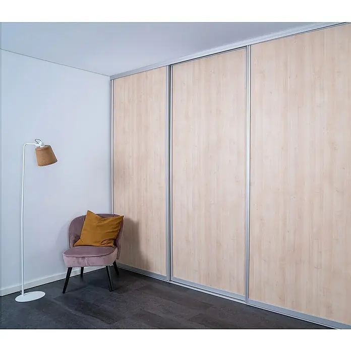 Room Plaza Easy Doing Schiebetür-Bau-SetAhorn Naturwuchs, Profilfarbe: Silber - Ein modernes Zimmer mit einem Kleiderschrank mit Schiebetüren in Holzoptik, einem trendigen Sessel und einer Stehlampe.