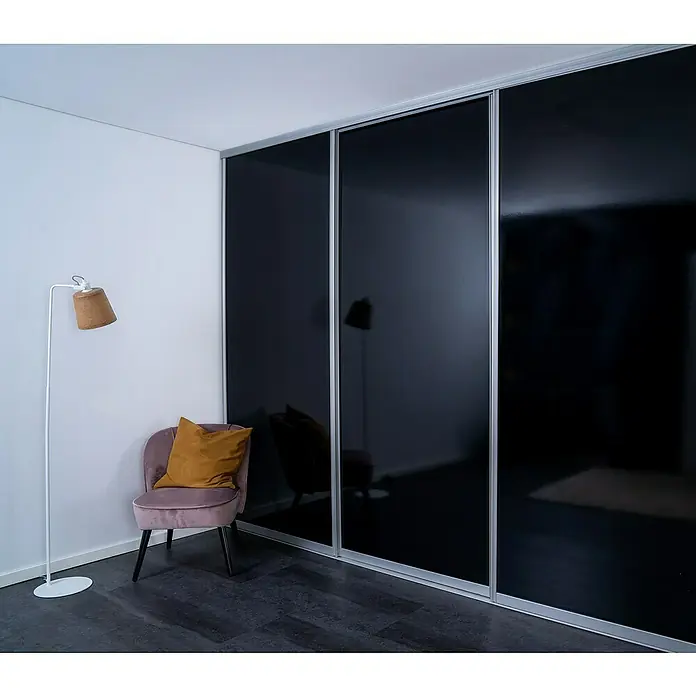 Room Plaza Easy Doing Schiebetür-Bau-Set - Hochglanz Schwarz/Hochglanz Weiß, Farbe Beschlag: Silber - Eine elegante Inneneinrichtung mit einem schwarzen Schiebetürenschrank, einem lachsfarbenen Sessel mit Kissen und einer Stehlampe.