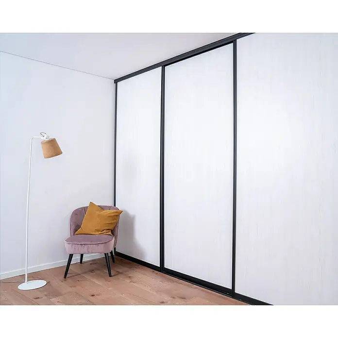 Room Plaza Easy Doing Schiebetür-Bau-Set - Pinie weiß, Farbe Beschlag: Schwarz - Elegantes Schlafzimmer mit einem modernen, dreiteiligen Schiebetürenschrank in Weiß und Schwarz, der Stauraum und Stil vereint.