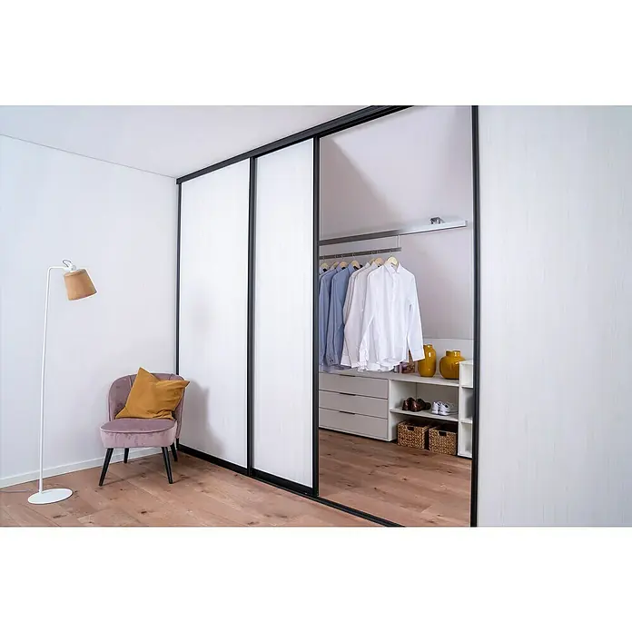 Room Plaza Easy Doing Schiebetür-Bau-SetPinie weiß, Profilfarbe: Schwarz - Ein begehbarer Kleiderschrank mit Schiebetüren und Kleiderstange. Ein bequemer Stuhl mit Kissen und eine Stehlampe ergänzen das moderne Design.