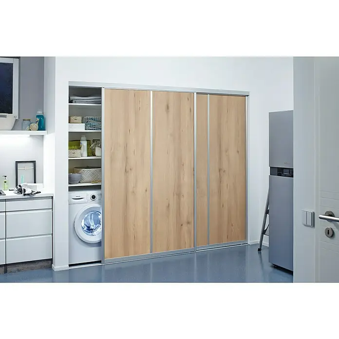 Room Plaza Easy Schiebetür-Bau-Set - Buche Naturwuchs/Ahorn Naturwuchs, Farbe Beschlag: Silber - Das Bild zeigt eine moderne Waschküche mit einer Waschmaschine, Regalen und einer Schiebetür mit Holzstruktur.