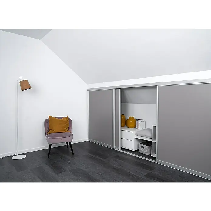 Room Plaza Easy Doing Schiebetür-Bau-Set Kniestock - Taupe, Farbe Beschlag: Silber - Ein stilvolles Dachzimmer mit einem grauen Schiebetürenschrank, einem lila Sessel mit gelbem Kissen und einer Stehlampe, die eine gemütliche Atmosphäre schafft.