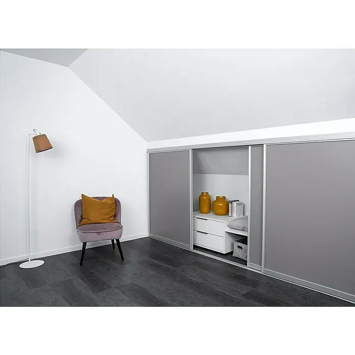 Room Plaza Easy Doing Schiebetür-Bau-Set Kniestock - Taupe, Farbe Beschlag: Silber - Helles Interieur mit einem Kleiderschrank mit Schiebetüren in Grau. Ein Sessel und eine Lampe vervollständigen das elegante Design.