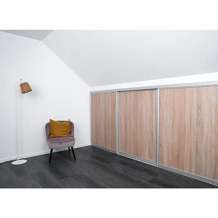 Room Plaza Easy Doing Schiebetür-Bau-Set Kniestock - Eiche geplankt, Farbe Beschlag: Silber - Das Bild zeigt ein modernes Zimmer mit einem großen Holzschiebetürenschrank, einem lila Sessel mit Kissen und einer Stehlampe.