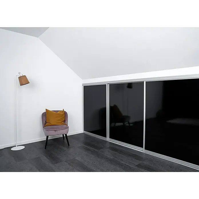 Room Plaza Easy Doing Schiebetür-Bau-Set Kniestock - Hochglanz Schwarz/Hochglanz Weiß, Farbe Beschlag: Silber - Elegantes Zimmer mit Kleiderschrank mit schwarzen Schiebetüren, Sessel und Stehlampe. Der stilvolle Kleiderschrank ist ein Highlight des Raums.