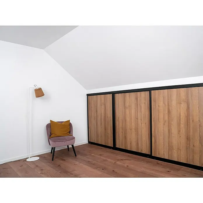 Room Plaza Easy Doing Schiebetür-Bau-Set KniestockEiche Country, Profilfarbe: Schwarz - Attraktives Zimmer mit großem Holzschrank, Sessel mit Kissen und Stehlampe. Der Holzschrank ist ein echter Hingucker und bietet viel Stauraum.