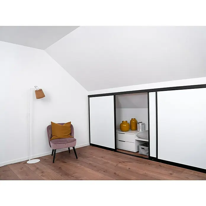 Room Plaza Easy Doing Schiebetür-Bau-Set KniestockSignalweiß, Profilfarbe: Schwarz - Einladendes Zimmer mit stilvollem Kleiderschrank mit Schiebetüren, gemütlichem Sessel und einer eleganten Stehlampe, die ein warmes Ambiente schafft.