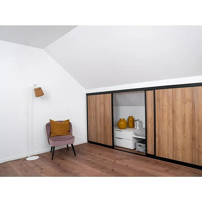 Room Plaza Easy Doing Schiebetür-Bau-Set KniestockEiche Country, Profilfarbe: Schwarz - Zimmer mit einem Kleiderschrank mit Schiebetüren aus hellem Holz, einem Sessel und einer Stehlampe.