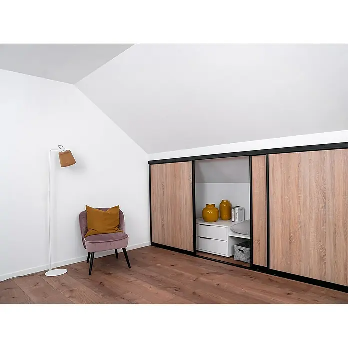 Room Plaza Easy Doing Schiebetür-Bau-Set KniestockEiche geplankt, Profilfarbe: Schwarz - Einrichtung eines Dachgeschosszimmers mit Schrank mit Schiebetüren, Stehlampe und rosa Samtstuhl mit goldenem Kissen.