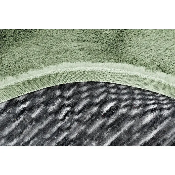 Fellteppich Happy - Jade, Durchmesser: 160 cm, 100 % Polyester (Flor) - Detailaufnahme eines runden Teppichs in Salbeigrün, der die Textur und die Verarbeitung des Teppichrückens zeigt.