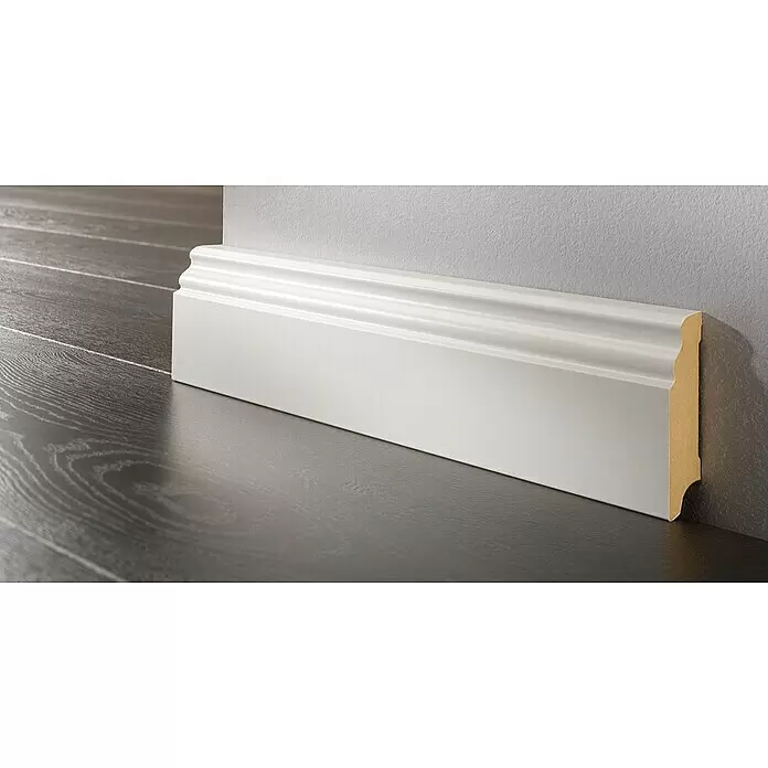 LOGOCLIC Sockelleiste Weiß - 260 cm x 17 mm x 100 mm, MDF, Weiß, Beschichtet - Weiße, dekorative Sockelleiste auf dunklem Holzboden an heller Wand installiert.