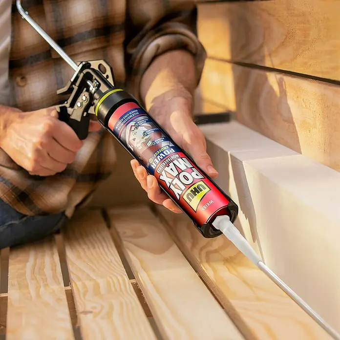 UHU Poly Max Montagekleber Power - Weiß, 425 g, Kartusche - Nahaufnahme eines Mannes, der mit einer Kartuschenpistole UHU Poly Max Montagekleber auf Holz aufträgt, ideal für Heimwerkerprojekte.