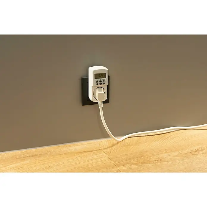 Temporizador - Digital, Potencia de conexión máx.: 1.800 W - Temporizador digital enchufado a una toma de corriente. Muestra la hora actual y tiene botones para programar los horarios de encendido y apagado.