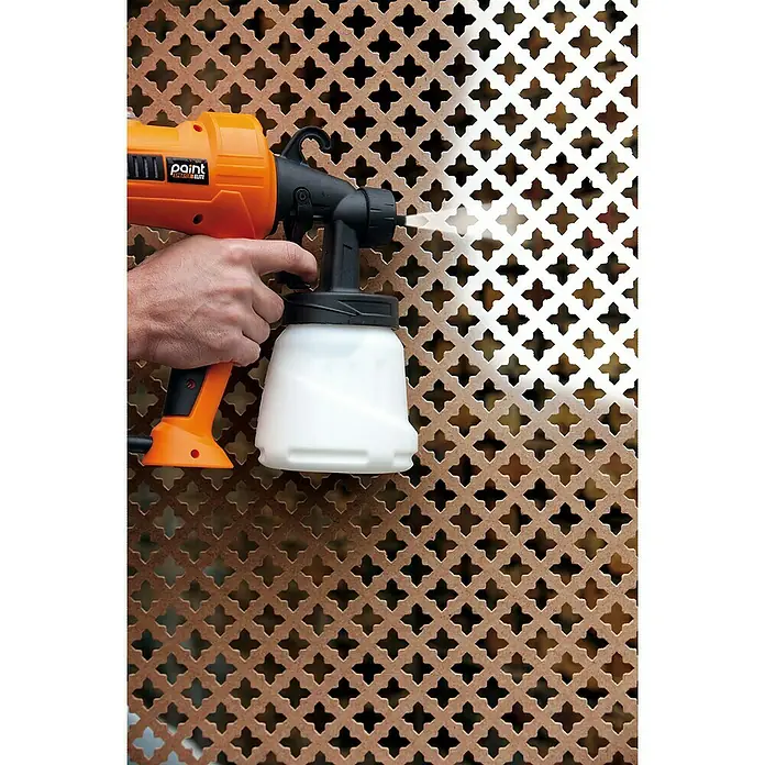 Sistema de pulverización de pintura Paint Sprayer - 400 W, Caudal: 0,5 l/min - Pistola de pulverización de pintura en uso. La pintura se aplica uniformemente a una superficie estampada, lo que resulta en un acabado profesional.