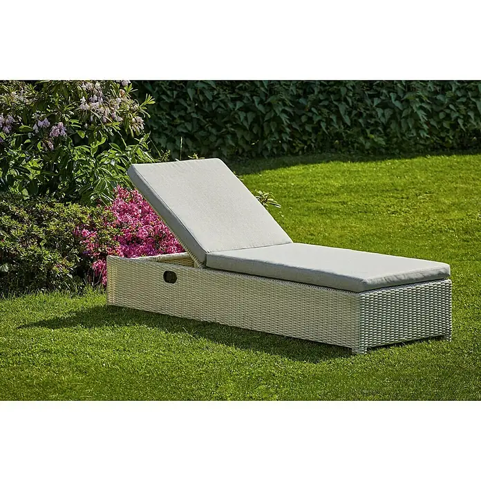 Sunfun Paula Gartenliege - B x T: 71 x 194 cm, Weiß/Grau, Metall, Rückenlehne verstellbar - Eine elegante graue Gartenliege aus Rattan mit weicher Polsterung steht auf einem gepflegten Rasen neben blühenden Büschen.