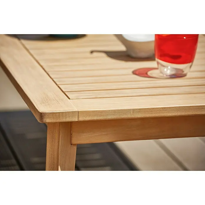 Sunfun Kathrin Loungemöbel-Set - 4 -tlg., Max. Personenzahl: 4, Akazie, Anthrazit/Naturbraun - Nahaufnahme eines Gartentisches aus Holz mit Getränk und Geschirr, der die Tischplatte und die Beine zeigt.