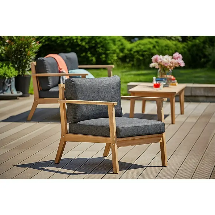 Sunfun Kathrin Loungesessel - B x T x H: 74 x 81 x 78 cm, Anthrazit/Braun - Bild eines Outdoor-Sessels aus Holz mit grauen Polstern, der auf einer Terrasse steht. Einladend und stilvoll für entspannte Stunden im Freien.