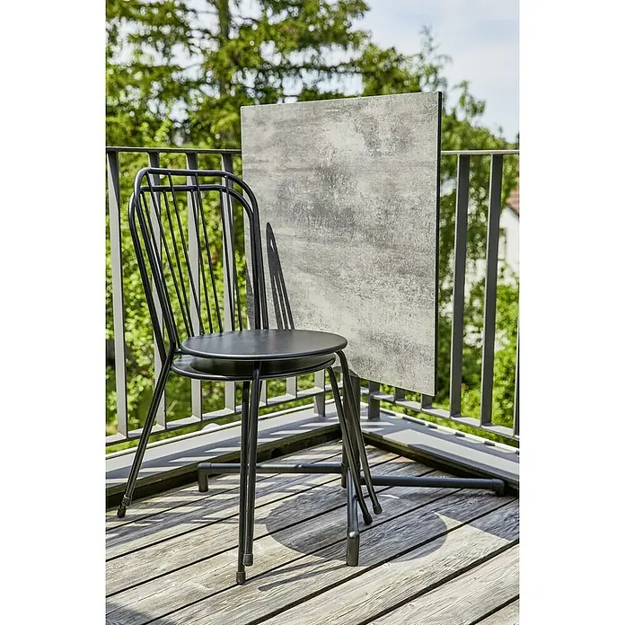 Sunfun Balkonmöbel-Set Melina - 3 -tlg., Stahl, Schwarz, Gartentisch klappbar - Schwarzer Stuhl mit rundem Sitz und Tisch mit Steinplatte auf einem Holzbalkon.