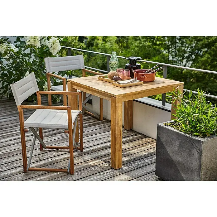 Sunfun Laura Gartentisch - L x B x H: 90 x 90 x 76 cm, Akazie, Quadratisch, Braun - Ein einladender Außenbereich mit einem quadratischen Holztisch, umgeben von zwei Regiestühlen, perfekt für entspannte Stunden im Freien.