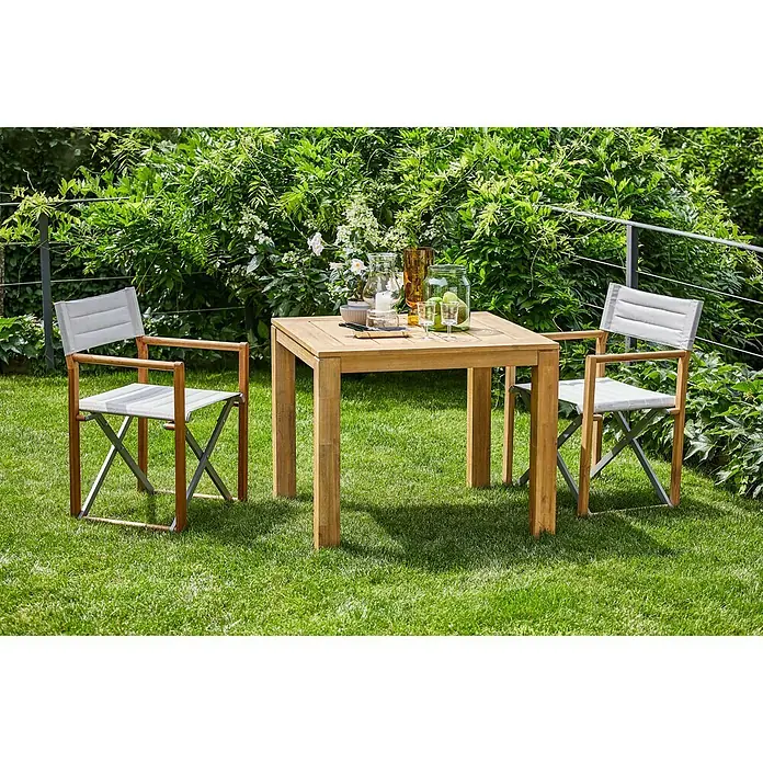 Sunfun Kathrin Gartenstuhl - Akazienholz, Klappbar, Hellgrau, Teakbraun, B x T x H: 59,5 x 54 x 86,5 cm - Gartenset mit quadratischem Tisch und zwei Stühlen auf Rasen. Das Set ist aus Holz und grauem Stoff gefertigt und wirkt einladend.