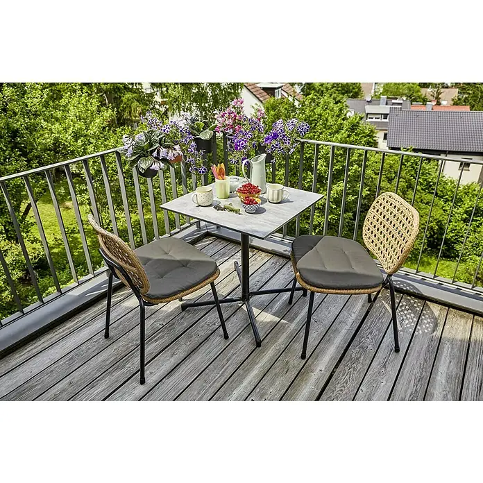 Sunfun Balkonmöbel-Set Melina - 3 -tlg., HPL/Stahl/PE-Geflecht, Schwarz/Braun, Gartentisch klappbar - Ein Balkon mit einem Tisch und zwei Stühlen, dekoriert mit Blumen und Geschirr, lädt zum Verweilen im Freien ein.