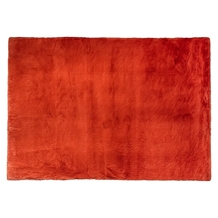 Hochflorteppich Candy - Terra, 160 x 120 cm, 100 % Polyester - Ein weicher, rotbrauner Teppich liegt auf einem schwarzen Hintergrund und zeigt seine luxuriöse Textur und Farbe.