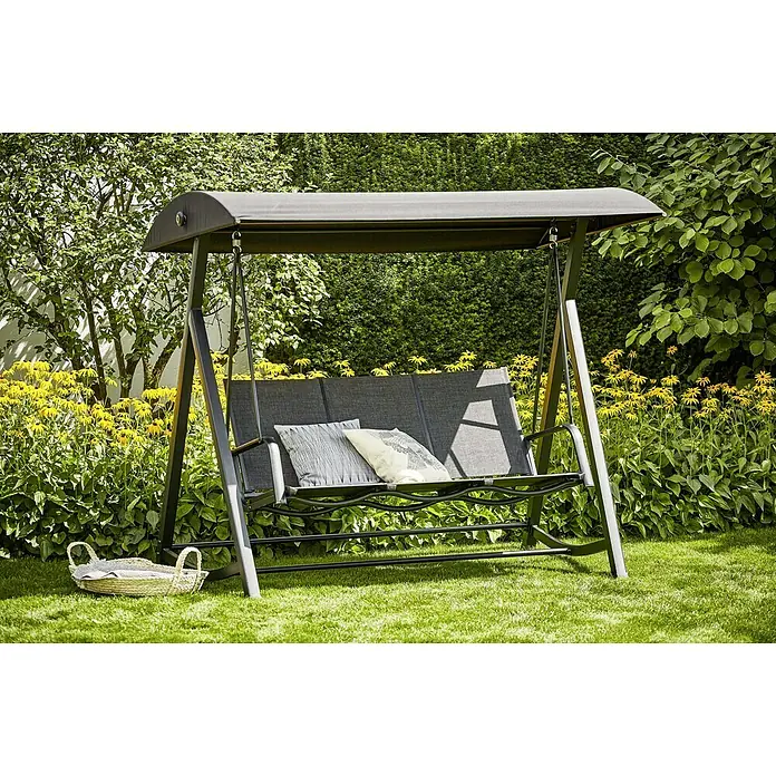 Sunfun Melina Hollywoodschaukel - B x T x H: 209 x 113 x 171 cm, Kunststoff, Schwarz - Eine graue Gartenschaukel mit zwei Kissen steht auf einem Rasen vor blühenden Blumen, perfekt für entspannte Stunden im Freien.