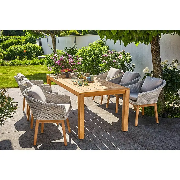 Sunfun Laura Gartentisch - L x B x H: 220 x 100 x 76 cm, Akazie, Rechteckig, Naturbraun - Einladende Gartenszene mit einem eleganten Teakholztisch und sechs stilvollen Rattansesseln mit bequemen grauen Kissen. Perfekt für entspannte Stunden im Freien.