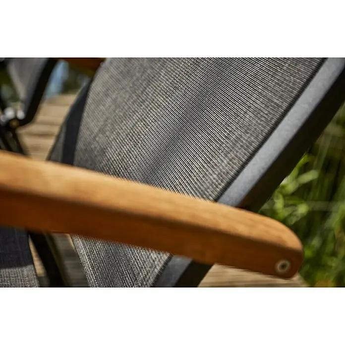 Sunfun Melina Sillón de posiciones - Negro, Teca/Textiline/Aluminio, Respaldo regulable - Primer plano de una silla de jardín con reposabrazos de madera y tela de malla gris. La silla parece cómoda para relajarse al aire libre.