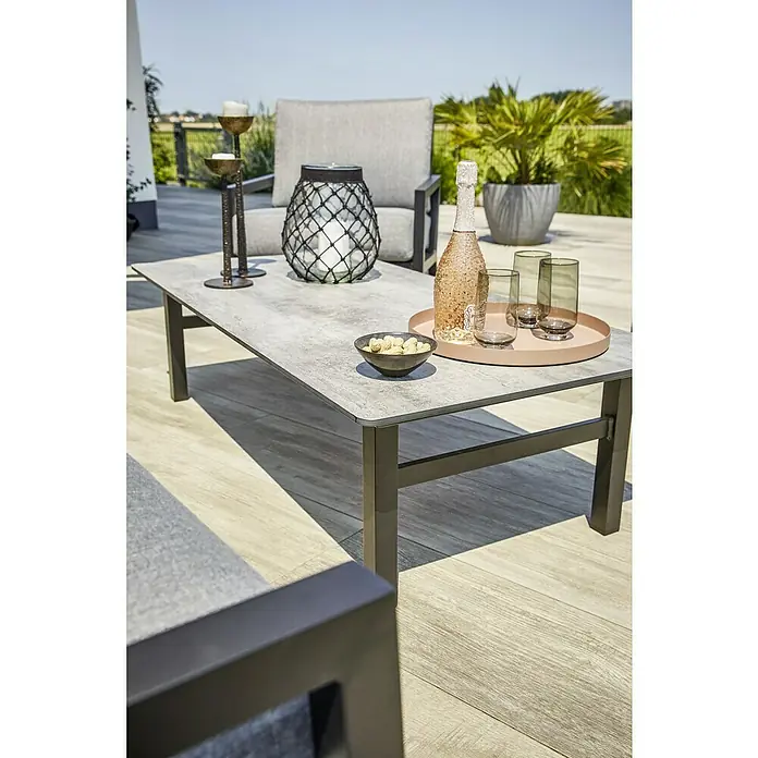 Sunfun Melina LoungetischL x B x H: 135 x 67 x 36 cm, Hochdruck-Schichtpressstoff (HPL), Schwarz - Nahaufnahme eines modernen Couchtisches mit Getränken und Dekoration auf einer Terrasse.