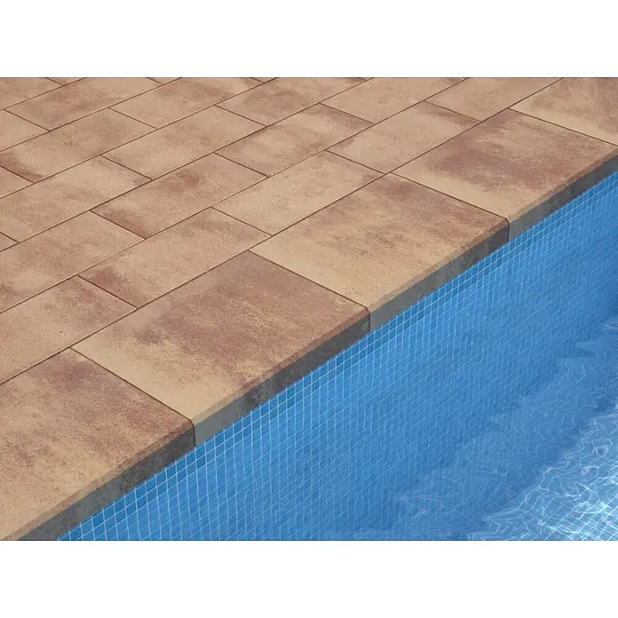 SAS Tessera Poolrandplatte - 32,8 x 50 x 6 cm, Bronze, Beton - Dieses Bild zeigt einen Pool mit rechteckigen Terrassenplatten in einem warmen Farbton, die eine elegante Umrandung bilden.
