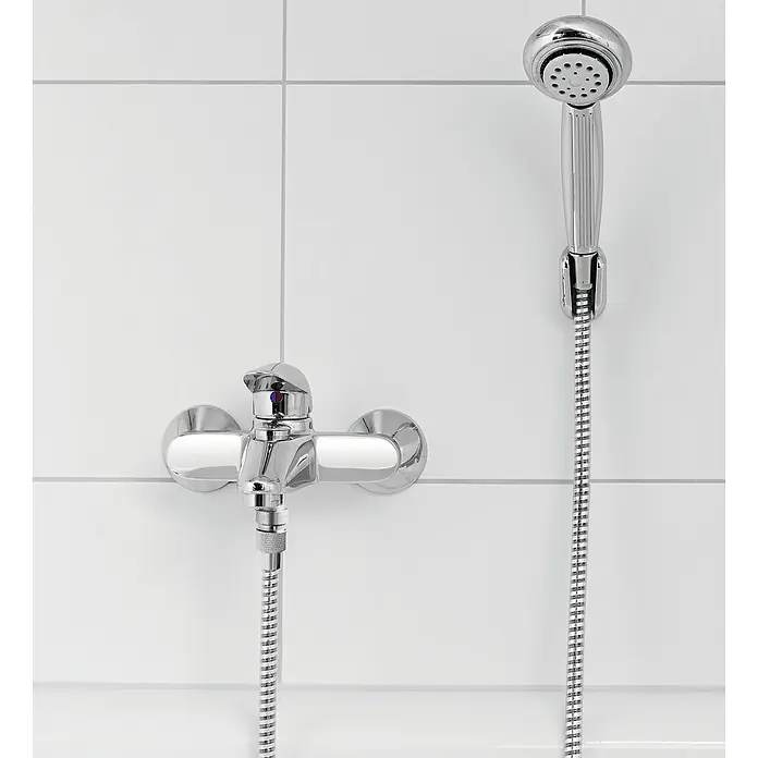 Puregreen Wassersparverschraubung - Geeignet für: Brausearmaturen, Chrom - Das Bild zeigt eine moderne Chrom-Badewannenarmatur mit Brausekopf vor einem Hintergrund aus weißen Fliesen. Die Armatur ist glänzend und neu.
