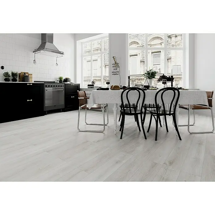 Fixed Vinylboden - Weißeiche, Landhausdiele, 1.219 x 184 x 2,5 mm - Elegante Küche mit klaren Linien, dunklen Schränken und einem Esstisch mit stilvollen Stühlen, die ein modernes und einladendes Ambiente schaffen.