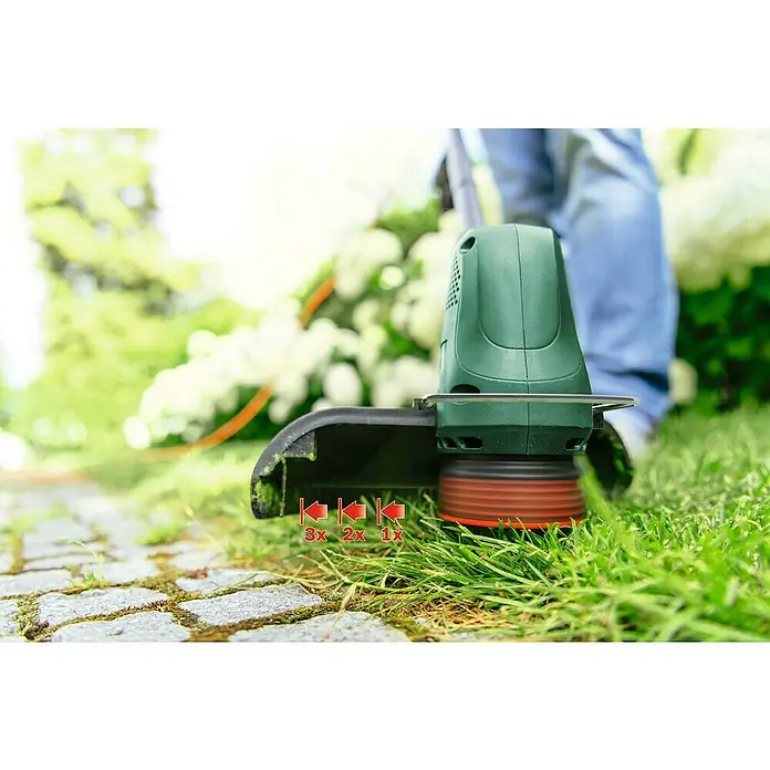 Bosch Elektro-Rasentrimmer EasyGrassCut 26 new - 280 W, Schnittbreite Faden: 26 cm - Nahaufnahme eines Rasentrimmers beim Schneiden von Gras, der die Präzision und Effizienz des Werkzeugs hervorhebt.