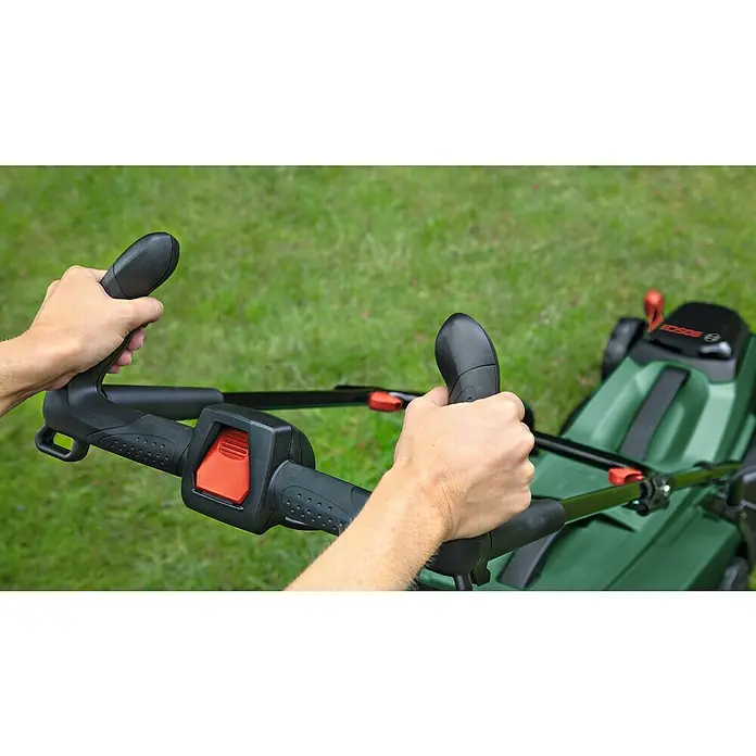 Bosch Power for All 18V Akku-Rasenmäher CityMower 18V-32-300 - 18 V, Ohne Akku, Schnittbreite: 32 cm - Eine Nahaufnahme der Hände, die den Griff eines Bosch Rasenmähers halten, mit Fokus auf die Bedienelemente und das grüne Gehäuse.