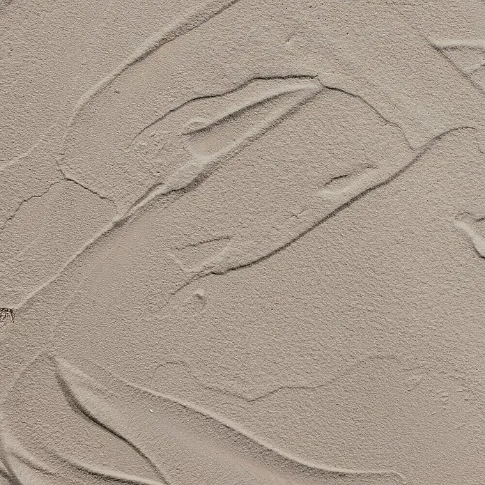 Talens Art Creation Pasta de color Beton - 100 ml, Gris pardo oscuro - Primer plano de una textura hecha de arena fina y clara con líneas suaves y curvas y sutiles detalles de sombreado.