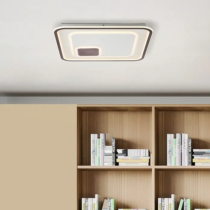 Brilliant LED-Wand- & Deckenleuchte Argulon - 55 W, L x B x H: 6 x 50 x 50 cm, Weiß, Warmweiß - Moderne Deckenleuchte mit quadratischem Design und warmem Licht, ideal für stilvolle Innenräume mit Bücherregal im Hintergrund.