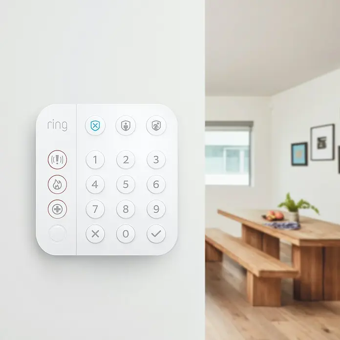 Ring Alarm Tastenfeld Keypad 2. Gen. - Weiß, 2,3 x 10 x 14,9 cm - Nahaufnahme eines Ring-Sicherheitssystems Keypad mit Zahlentasten und Symbolen zur Steuerung der Alarmanlage an einer weißen Wand.