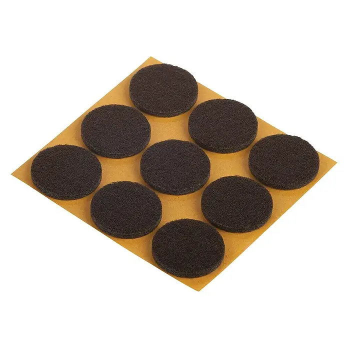 Suki Patín antideslizante para alfombras - Diámetro: 25 mm, Marrón, Pegado, 9 ud. - Primer plano de deslizadores de fieltro marrón para muebles en una lámina, ideales para proteger el suelo de arañazos.