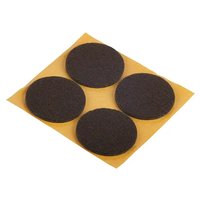 Suki Patín antideslizante para alfombras - Diámetro: 35 mm, Marrón, Pegado, 4 ud. - Cuatro almohadillas negras y redondas para muebles sobre un soporte amarillo. Ideal para proteger pisos y muebles de rayones.