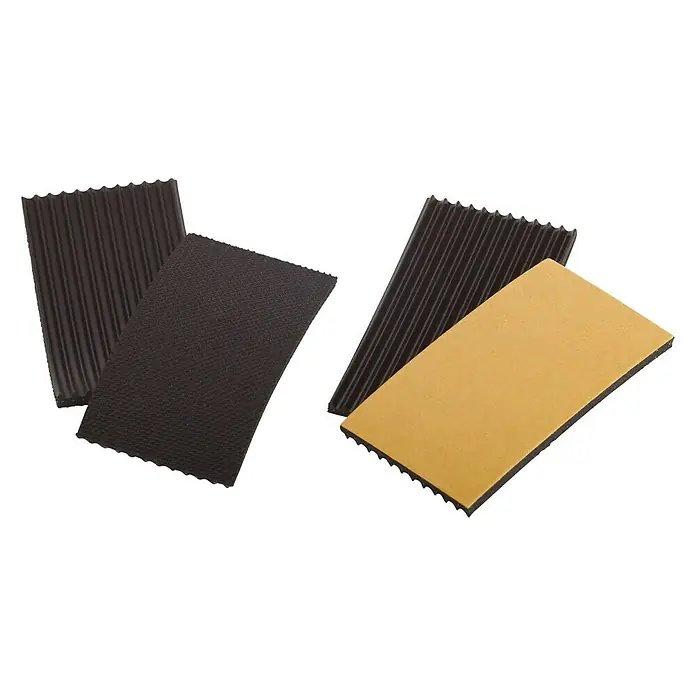 Fix-o-moll Teppichgleiter - B x L: 35 x 70 mm, Kleben, 2 -tlg. - Nahaufnahme von vier selbstklebenden Antirutschmatten mit unterschiedlichen Oberflächenstrukturen auf schwarzem Hintergrund.