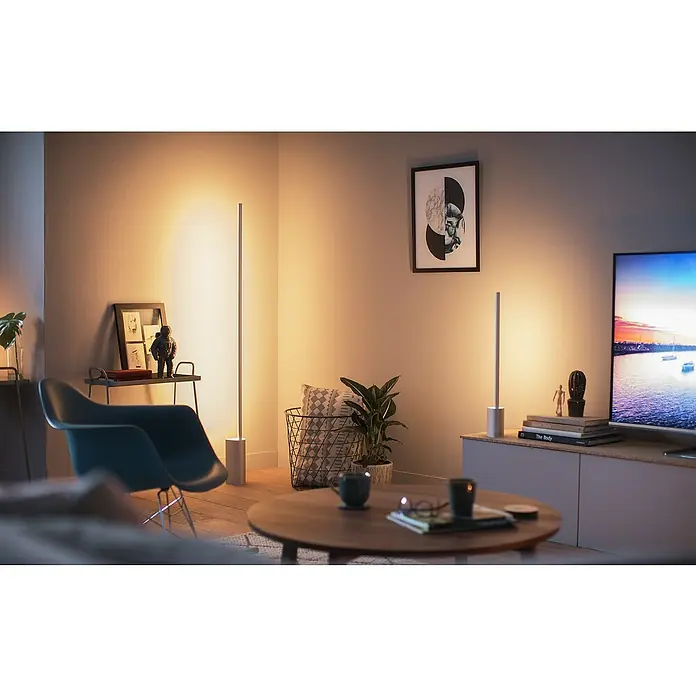 Philips Hue LED-Tischleuchte GRADIENT SIGNE - L x B x H: 11 x 11 x 55,3 cm, Weiß, RGBW - Elegante LED-Stehleuchten in einem modernen Wohnzimmer, die warmes, einladendes Licht spenden und eine gemütliche Atmosphäre schaffen.