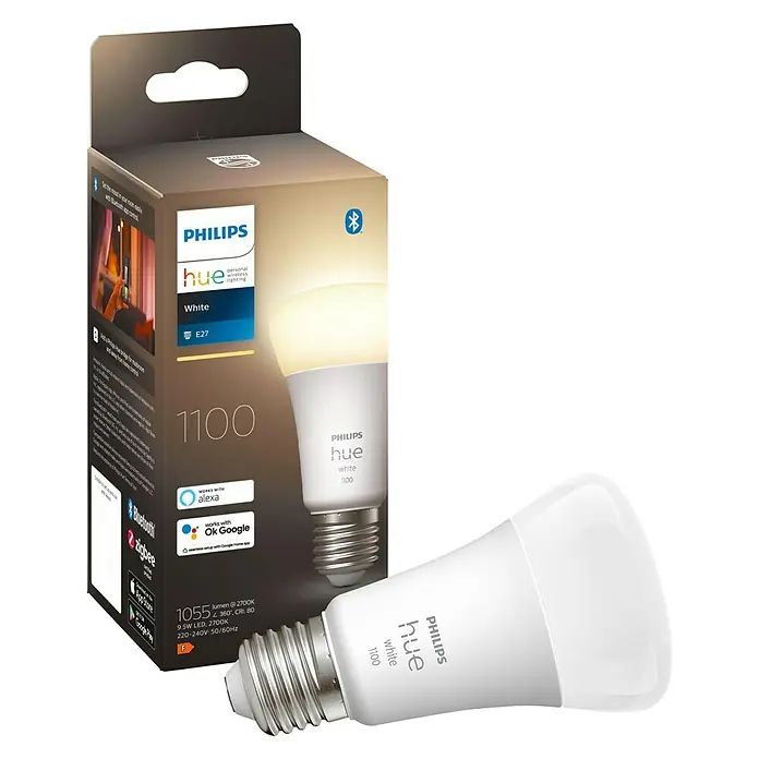 Philips Hue Bombilla LED White - E27, Intensidad regulable, Blanco cálido, 1.055 lm, 9,5 W, 1 ud. - Primer plano de una bombilla Philips Hue White y su embalaje. Ofrece 1100 lúmenes de brillo y es controlable por Bluetooth.