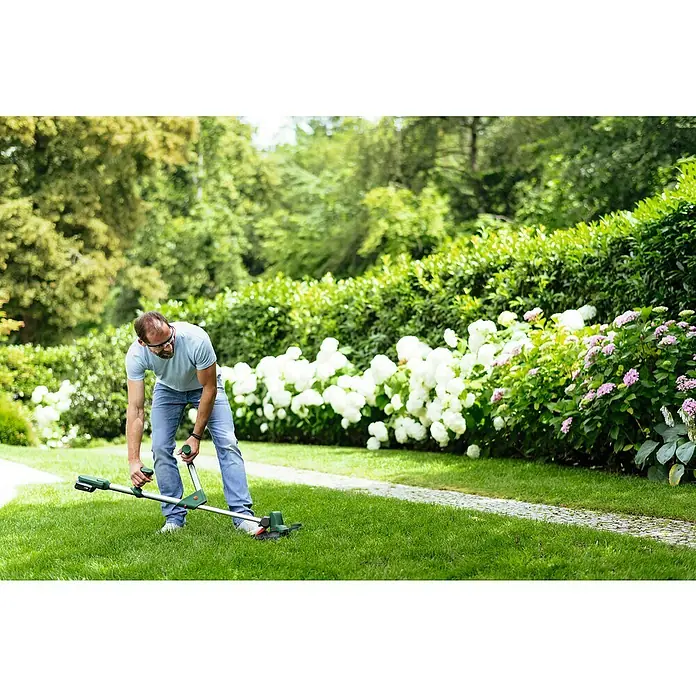 Bosch Power for All 18V Akku-Rasentrimmer UniversalGrassCut 18V-26 - 18 V, Li-Ionen, Ohne Akku - Ein Mann benutzt einen Bosch Rasenkantenschneider im Garten, um präzise Rasenkanten zu schneiden und den Garten zu pflegen.