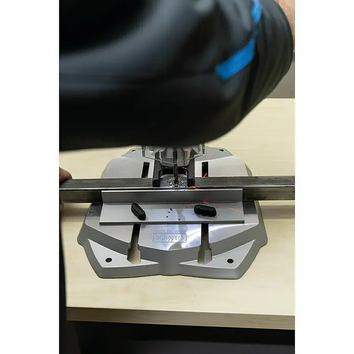 Scheppach Tischbohrmaschine DP 60 - 710 W, Leerlaufdrehzahl: 0 U/min - 2.600 U/min, Spannweite Bohrfutter: 1,5 mm - 13 mm - Nahaufnahme einer Scheppach Bohrmaschine in Aktion, die präzise Löcher in ein Metallstück bohrt, wobei Späne fliegen.