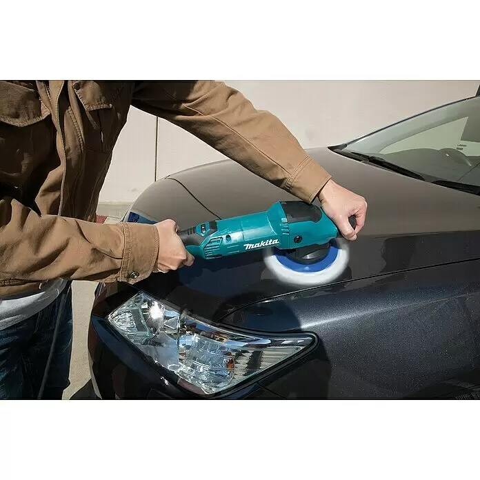 Makita Rotationspolierer PO5000C - 900 W, Durchmesser Scheibe: 125 mm - Eine Person poliert ein dunkelgraues Auto mit einer tealfarbenen Makita Poliermaschine.