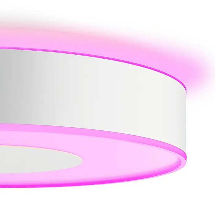 Philips Hue LED-Deckenleuchte rund Infuse - 52,5 W, Ø x H: 42,5 x 8,4 cm, Weiß, Mehrfarbig - Nahaufnahme einer runden LED-Deckenleuchte mit weißer Oberfläche und pinkfarbener Umrandung, die ein modernes und stilvolles Design zeigt.