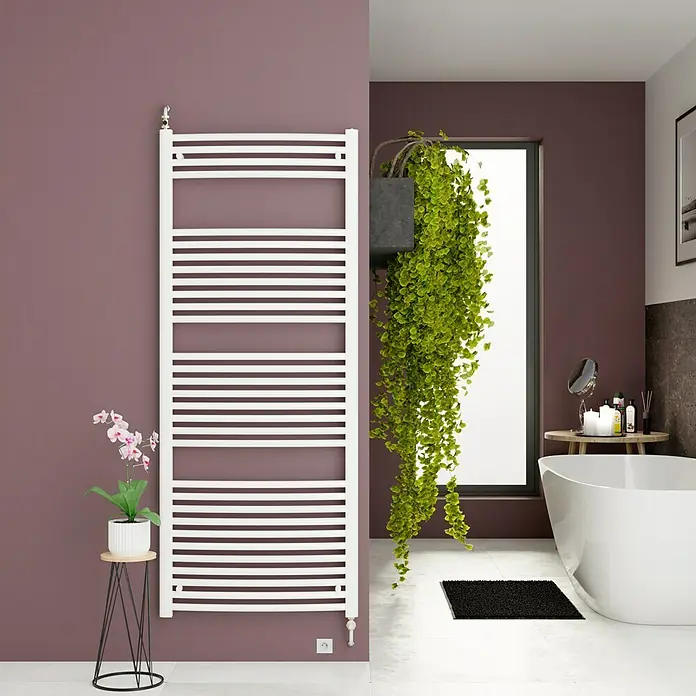 Admiral Badheizkörper Kairo - B x H: 600 x 1.570 mm, Wärmeleistung bei Vorlauftemperatur von 75 °C (D: 50): 830 W - Elegantes Badezimmer mit einem weißen Handtuchwärmer an der Wand, ergänzt durch eine stilvolle Dekoration mit Pflanzen.