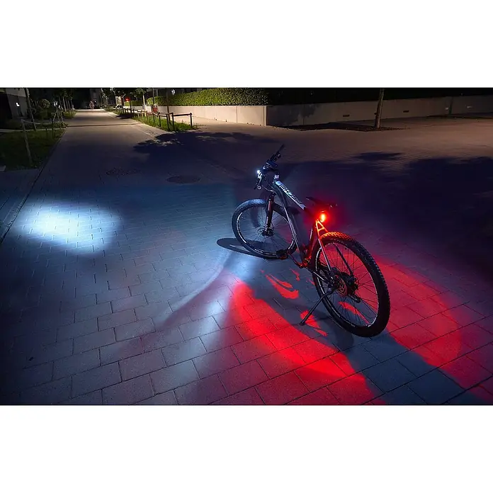 Fischer LED-Akkuleuchten-Set Twin - 5 -tlg., Beleuchtungsstärke: 50 lx, Leuchtdauer: 4 h, Spritzwassergeschützt - Ein Fahrrad mit Vorder- und Rückleuchten, das die Straße hell erleuchtet. Ideal für Fahrten in der Dämmerung oder Dunkelheit, sorgt für Sicherheit im Straßenverkehr.